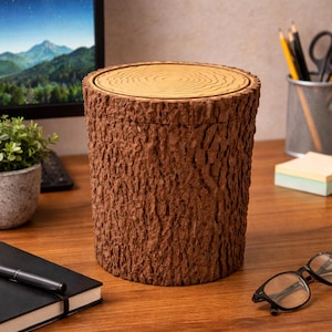 May include: A cylindrical container designed to resemble a tree stump. The exterior is textured brown, mimicking bark, with a lighter wood-toned top featuring concentric circles. This decorative item is suitable for desk organization.