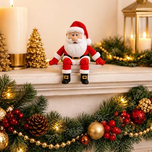 May include: A Santa Claus figurine with a red hat, red coat, white beard, black belt with a gold buckle, and black boots. The figure is seated with legs dangling, featuring a smooth, matte finish and a cartoon-like facial expression.