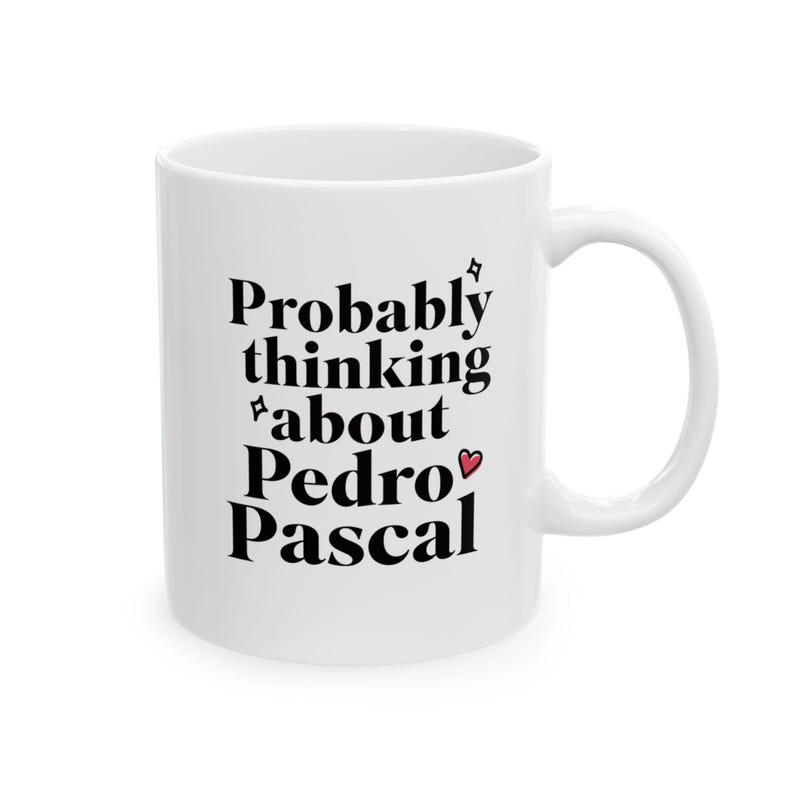 Puede incluir: Taza de cer&aacute;mica blanca con la frase "Probably thinking about Pedro Pascal" en negro. La taza tiene un asa curva y un peque&ntilde;o coraz&oacute;n rojo. Un regalo divertido.