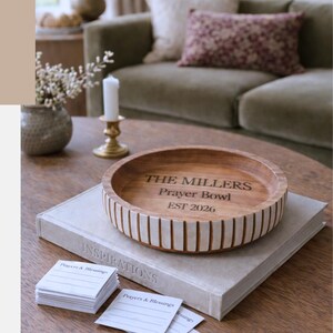 May include: A wooden prayer bowl with engraved text, resting on a book, with the text "THE MILLERS Prayer Bowl EST 2026". The image also includes the text "8 CUSTOM ENGRAVED GIFTS FOR THE CHIC Woman You Know".