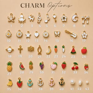 May include: A collection of forty-three small metal charms labeled with numbers, featuring various shapes including animals, fruits, musical notes, celestial bodies, and symbols, all arranged in a grid on a light tan background with the text CHARM Options.
