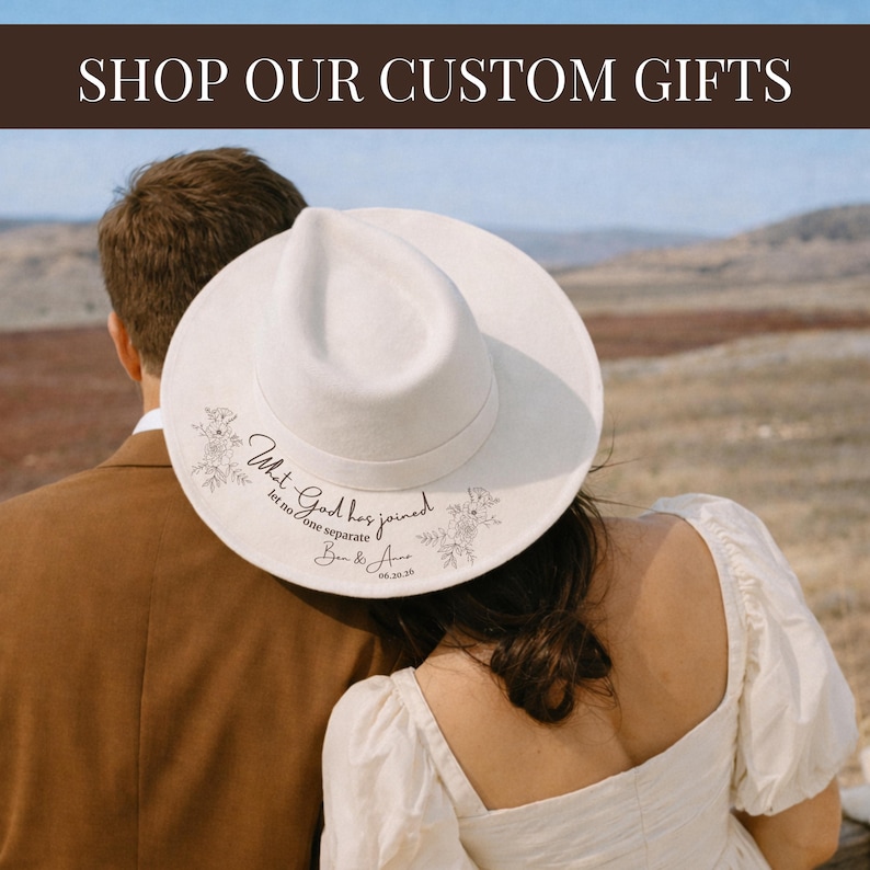 May include: A white fedora hat with floral and script design. The hat has the text "What God has joined, let no one separate" and a date. The image also includes the text "SHOP OUR CUSTOM GIFTS".