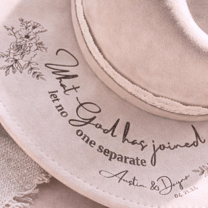 Puede incluir: Sombrero fedora beige claro con un dise&ntilde;o floral y el texto "What God has joined let no one separate Austin & Dayna 04.21.24". El sombrero tiene un ribete decorativo.