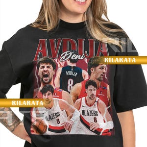 May include: Black adult unisex t-shirt featuring a collage of images of a basketball player. The shirt has the name "AVDIJA" in red and white lettering. The player's name "Deni" is also visible. The shirt also has the text "BLAZERS" and the number "8".
