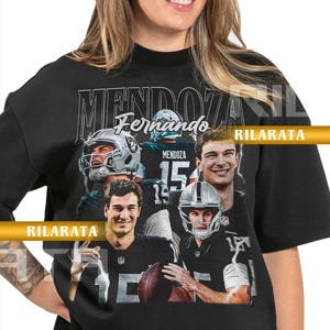 Pode incluir: Camiseta preta unissexo para adultos com uma colagem de imagens de um jogador de futebol americano. A camisa tem o nome "MENDOZA" e o número "15" impressos. O texto "Fernando" também está impresso na camisa.