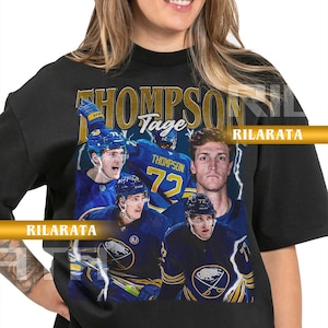 Könnte beinhalten: Schwarzes Unisex-T-Shirt für Erwachsene mit einer Collage von Eishockeyspielern in Blau und Weiß. Das Shirt zeigt den Schriftzug "THOMPSON" und die Nummer "72" im Vintage-Stil. Der Markenname "RILARATA" ist ebenfalls sichtbar.