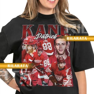 Könnte beinhalten: Schwarzes Unisex-T-Shirt für Erwachsene mit einer Collage von Patrick Kane in roter Hockey-Uniform. Das Shirt zeigt den Namen "KANE" und "Patrick". Die Nummer "88" ist ebenfalls sichtbar. Das Shirt ist ein fertiges Custom-Design.