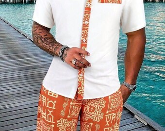 Puede incluir: Conjunto de camisa blanca de manga corta y pantalón corto a juego. La camisa tiene un ribete naranja estampado en el cuello, la tapeta y el bolsillo. El pantalón corto presenta un estampado naranja a juego. El conjunto se lleva en un muelle de madera con un fondo tropical.