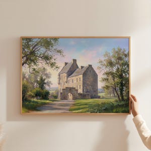 Può includere: Dipinto incorniciato di un castello in pietra con ingresso ad arco, immerso in campi verdi e alberi. L'opera presenta una morbida tavolozza di colori blu, verdi e gialli, con una cornice in legno marrone chiaro.