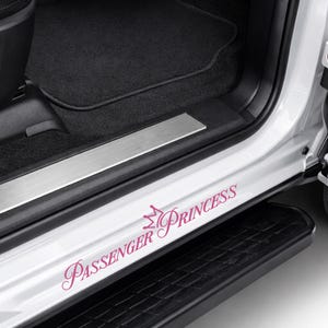 May include: White car door sill with the text "Passenger Princess" in a pink script font, with a crown graphic. The car door step is black.