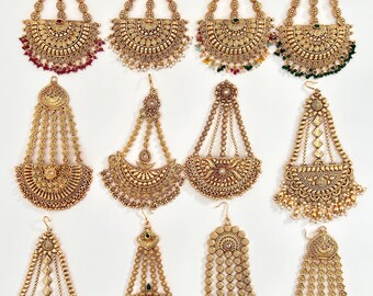 May include: A collection of twelve gold-toned metal hair ornaments, each featuring a decorative top piece connected by beaded chains to a semi-circular or circular base with intricate filigree patterns and dangling beads in various colors.