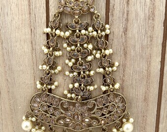 May include: An antique gold-toned headpiece with a floral design. The headpiece features clear, oval-shaped stones and small, round, white pearls. The piece is made of metal and has a decorative, ornate design.