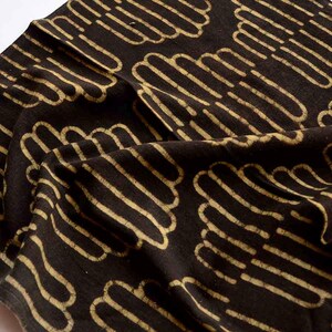 May include: Black fabric with a repeating pattern of tan, curved lines. The lines are arranged in a wavy, cloud-like pattern.