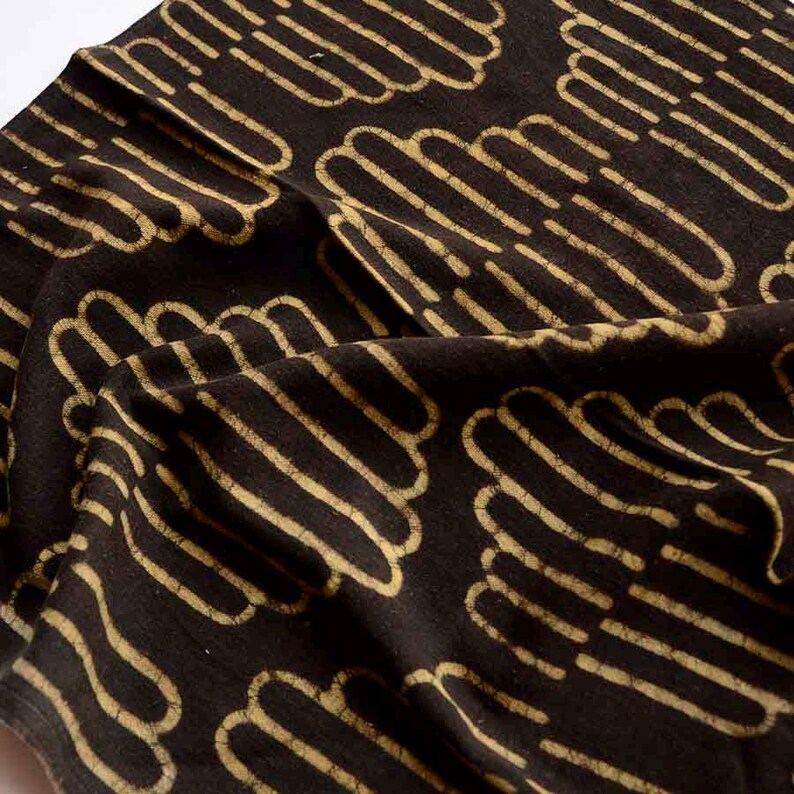 May include: Black fabric with a repeating pattern of tan, curved lines. The lines are arranged in a wavy, cloud-like pattern.