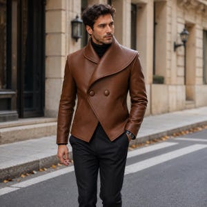 May include: A brown leather jacket with a wide shawl collar and double-breasted button closure, worn over a black turtleneck sweater and black trousers. The jacket features long sleeves and a structured fit, providing a clean and polished appearance.