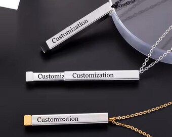 May include: Three silver necklaces with a bar pendant that can be engraved with a personalized message. The pendants are engraved with the word "Customization".