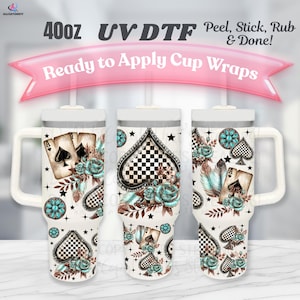 Peut inclure: Trois gobelets blancs avec poignées, chacun enveloppé d'un motif avec des cartes à jouer, des roses turquoise et un cœur à carreaux noir et blanc. Le texte de l'image indique "Ready to Apply Cup Wraps" et "40oz UV DTF".