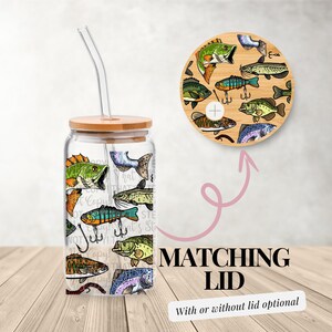 May include: A clear glass tumbler with a bamboo lid and straw, decorated with colorful fish illustrations and fishing hooks. The matching bamboo lid features similar fish designs. Text on the image reads "Matching Lid" and "With or without lid optional".