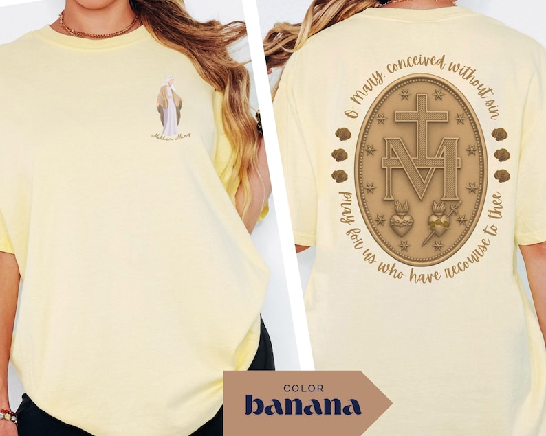 May include: Banana-colored t-shirt with a small illustration on the front and a detailed religious emblem on the back. The emblem features a cross, the letter M, and the text "O Mary conceived without sin, pray for us who have recourse to thee."