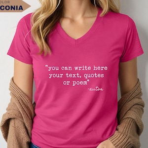 May include: A bright pink V-neck t-shirt featuring white typewriter-style text that reads: "you can write here your text, quotes or poem" followed by "-autor". The shirt is worn with a tan cardigan draped over the shoulders.