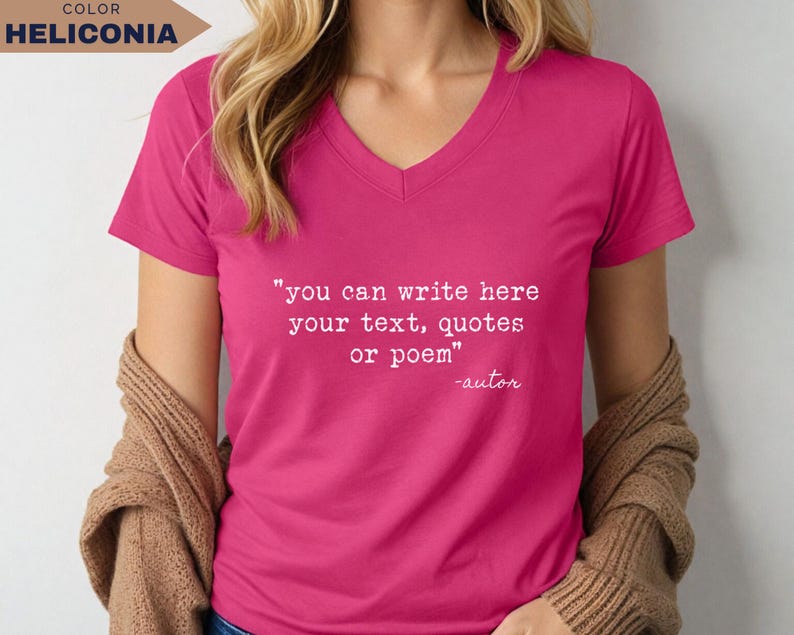 May include: A bright pink V-neck t-shirt featuring white typewriter-style text that reads: "you can write here your text, quotes or poem" followed by "-autor". The shirt is worn with a tan cardigan draped over the shoulders.