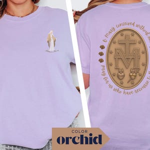 May include: Orchid-colored t-shirt featuring a religious illustration on the front and back. The front displays a figure with text, while the back showcases a detailed emblem with text. The shirt's color is highlighted with the word "ORCHID" at the bottom.