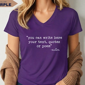 May include: A purple V-neck t-shirt featuring white printed text that reads: "you can write here your text, quotes or poem" followed by "-autor". The shirt has short sleeves and is worn with a tan cardigan draped over the shoulders.