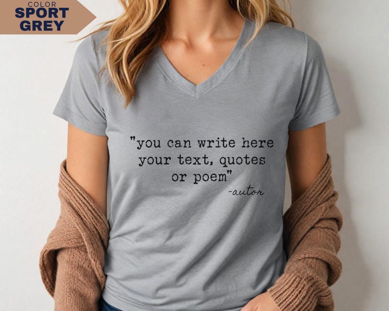 May include: A sport grey V-neck t-shirt featuring black typewriter-style text that reads: "you can write here your text, quotes or poem" followed by "-autor" on the next line. The shirt has short sleeves and a simple, clean design.