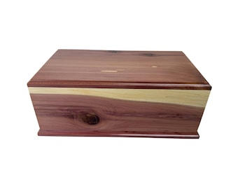 Peut inclure: Une boîte en bois rectangulaire avec un dessus et des côtés brun-rouge, et une bande de couleur plus claire au milieu. Le grain du bois est visible et la boîte a un design simple et élégant. La boîte est probablement utilisée pour le stockage.