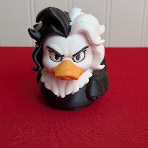 May include: A 3D-printed duck figurine with a unique design. The duck features a black and white hairstyle, a white ruffled collar, and an orange beak. The duck's body is black, and it has an angry expression. The figurine is on a red surface.
