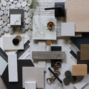 Può includere: Un moodboard con vari materiali e texture, tra cui legno, pietra, metallo e tessuto. Il pannello presenta una varietà di colori, tra cui bianco, grigio, nero e verde. I materiali sono disposti in modo visivamente accattivante, creando un design coeso ed elegante.
