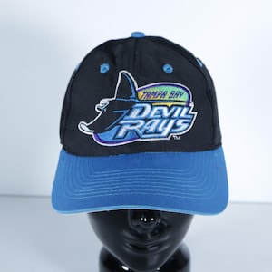 May include: Black and blue baseball cap featuring the Tampa Bay Devil Rays logo. The cap has a blue brim and a black crown with the team's logo embroidered in white, blue, green, and yellow.