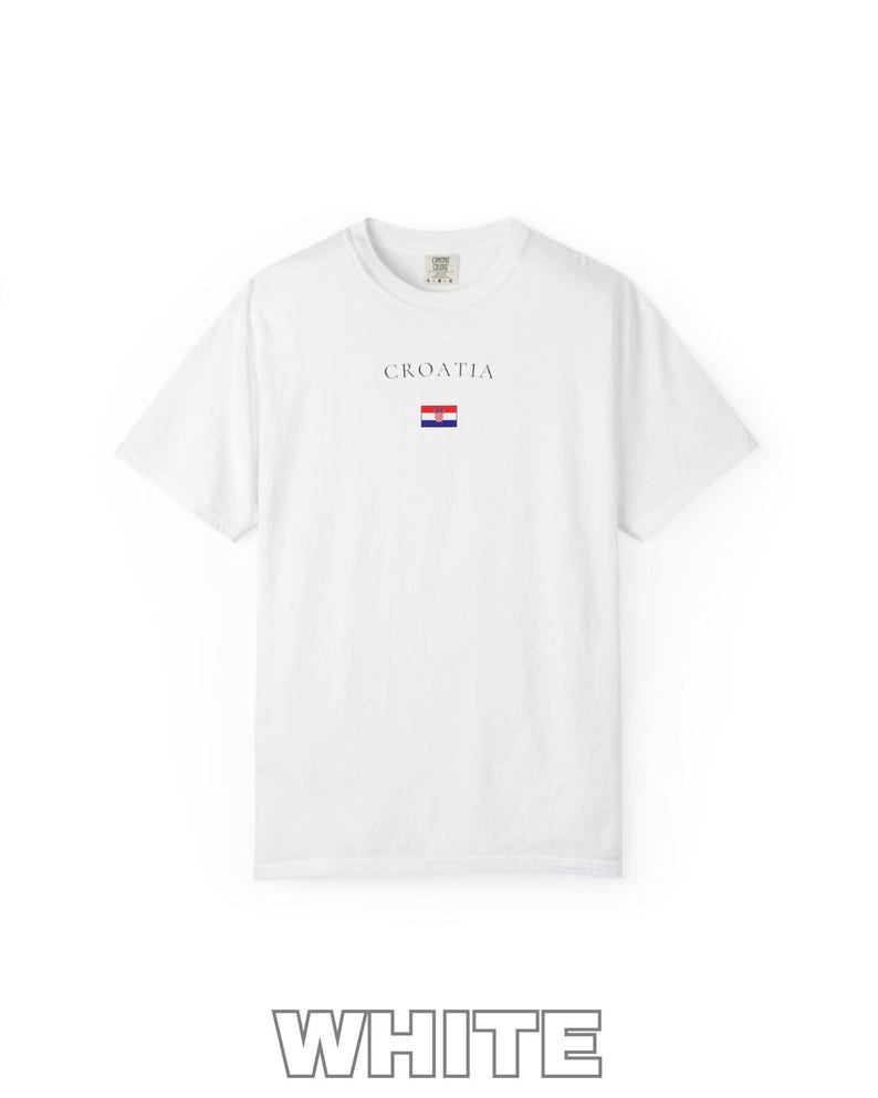 Peut inclure: T-shirt blanc avec le mot "CROATIA" imprim&eacute; au-dessus d'un petit drapeau croate. Le t-shirt est &agrave; manches courtes et a un col rond. Le mot "WHITE" est imprim&eacute; en gris en bas de l'image.