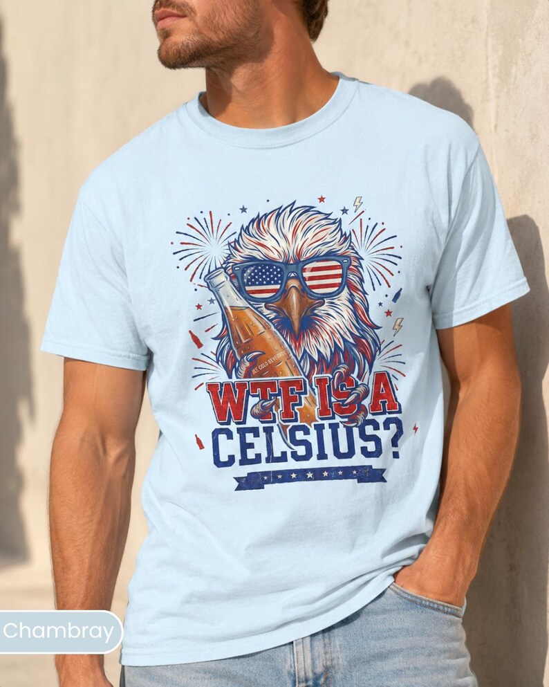 May include: A light blue t-shirt featuring a graphic of a bald eagle wearing American flag sunglasses and holding a glass bottle. The text reads WTF IS A CELSIUS? in red and blue lettering, surrounded by firework illustrations and small lightning bolts.