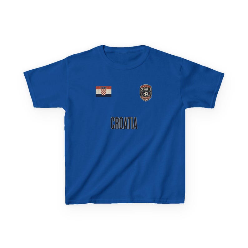 May include: A royal blue t-shirt featuring the word "CROATIA" in white block letters. Above the text are two emblems: the Croatian flag and a soccer ball with the word "CROATIA".