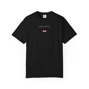 Peut inclure: T-shirt noir avec le mot "CROATIA" imprim&eacute; en blanc au-dessus d'un petit drapeau croate. Le mot "BLACK" est imprim&eacute; en grandes lettres grasses en bas du t-shirt.