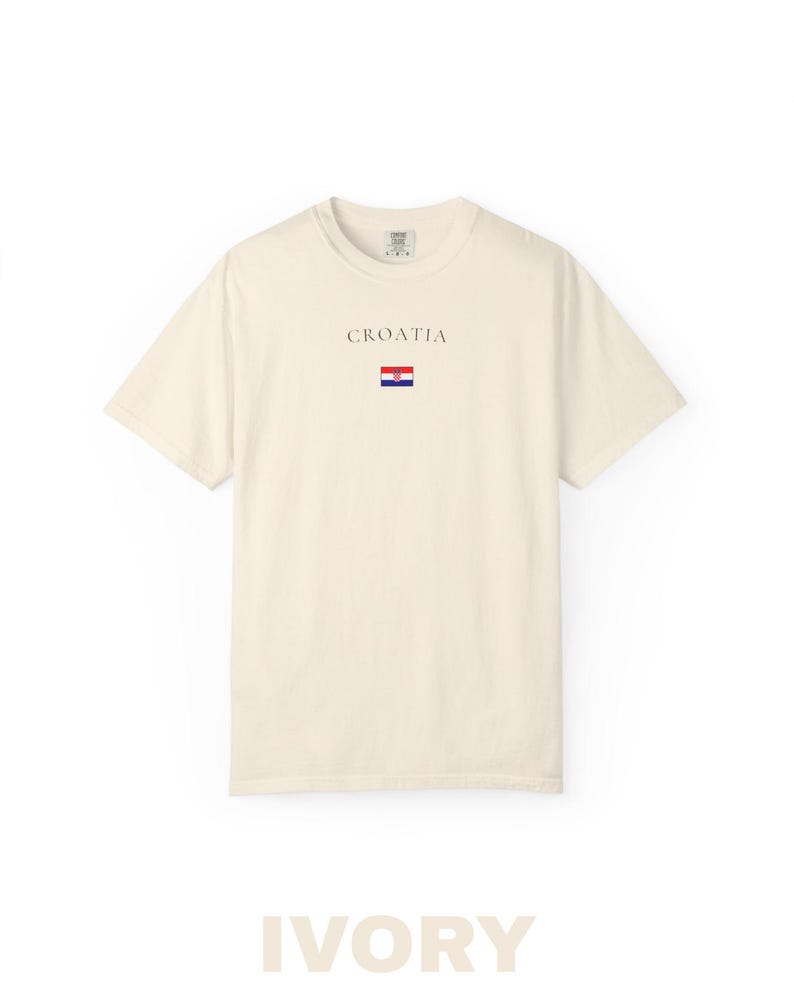 Peut inclure: T-shirt ivoire avec le mot "CROATIA" imprim&eacute; au-dessus d'un petit drapeau croate. Le t-shirt est de couleur unie, &agrave; manches courtes et col rond. Le mot "IVORY" est imprim&eacute; en grandes lettres en bas.