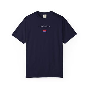Peut inclure: T-shirt bleu marine avec le mot "CROATIA" imprim&eacute; en blanc au-dessus d'un petit drapeau croate. Le mot "NAVY" est imprim&eacute; en grandes lettres blanches en bas. Le t-shirt est de style col rond.