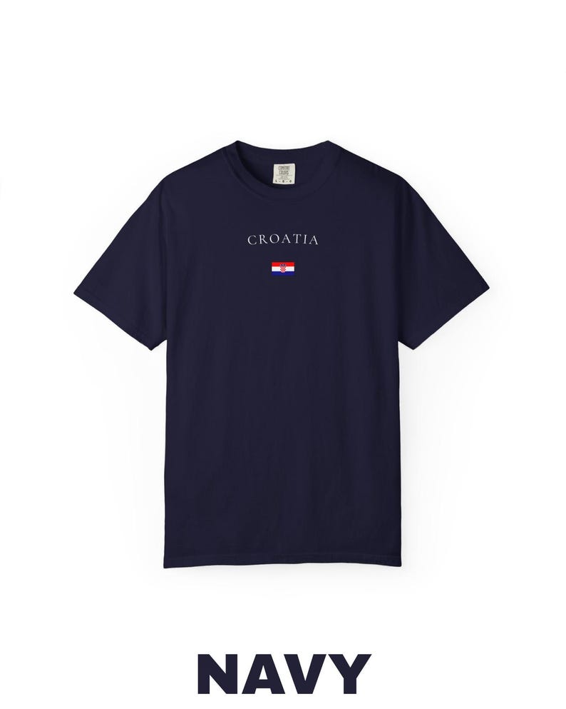 Peut inclure: T-shirt bleu marine avec le mot "CROATIA" imprim&eacute; en blanc au-dessus d'un petit drapeau croate. Le mot "NAVY" est imprim&eacute; en grandes lettres blanches en bas. Le t-shirt est de style col rond.