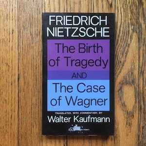 May include: A black and white book cover with the title "The Birth of Tragedy and The Case of Wagner" by Friedrich Nietzsche. The book cover has a purple and blue background.