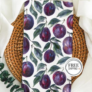 May include: A white background with a repeating pattern of watercolor plums and green leaves. The plums are a deep purple color with a slight sheen. The leaves are a dark green color with a light green center.