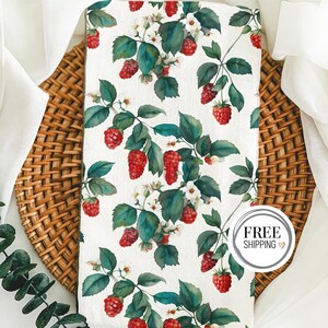 May include: White kitchen towel with a repeating pattern of red raspberries and green leaves. The towel has a white border and the words "FREE SHIPPING" are printed on a white circle with a brown heart.