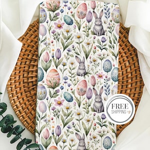 May include: White fabric with a repeating pattern of pastel pink and blue eggs, gray bunnies, and green and purple flowers. The fabric has a subtle watercolor effect.