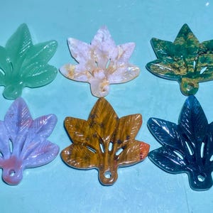 Puede incluir: Seis colgantes en forma de hoja de diferentes colores hechos de ágata. Las hojas están talladas con un diseño similar y tienen un agujero en la parte superior para colgar.
