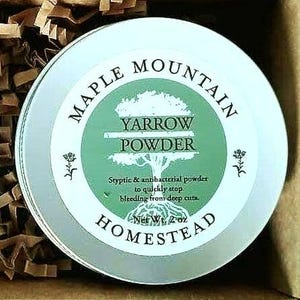 Peut inclure: Boîte ronde argentée de poudre de millefeuille de Maple Mountain Homestead. L'étiquette présente un cercle vert avec une illustration d'arbre et les mots "Yarrow Powder". Le pot contient 57 grammes et est une poudre styptique et antibactérienne.