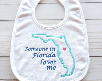Embroidered baby bib for Florida. Gift for baby. Baby shower gift. Embroidered baby bib. Bib saying "Someone in Florida loves me"  KBD20146