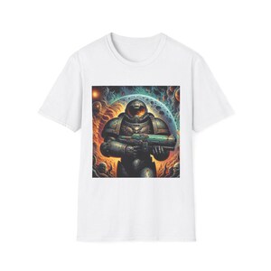 Può includere: T-shirt bianco con una stampa grafica di un marine spaziale che tiene un'arma su uno sfondo spaziale astratto e colorato.