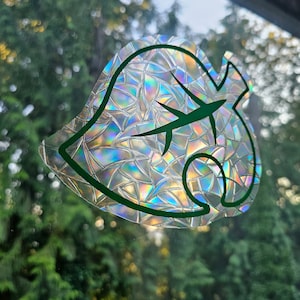 May include: A holographic sticker of a green leaf with a textured iridescent finish. The leaf is a popular symbol from the video game Animal Crossing.