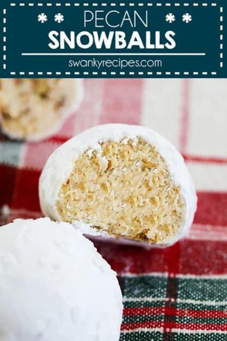 May include: Close-up of pecan snowballs, a type of cookie, on a red and green plaid tablecloth. The cookies are covered in powdered sugar and one is broken in half, revealing the pecan filling.
