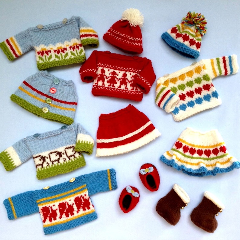 Peut inclure: Un ensemble de v&ecirc;tements en tricot pour poup&eacute;e, comprenant des pulls, des jupes, des chapeaux et des chaussons. Les v&ecirc;tements sont de diff&eacute;rentes couleurs, notamment rouge, bleu, vert, jaune et blanc. Les v&ecirc;tements sont d&eacute;cor&eacute;s de diff&eacute;rents motifs, notamment des c&oelig;urs, des fleurs et des animaux.